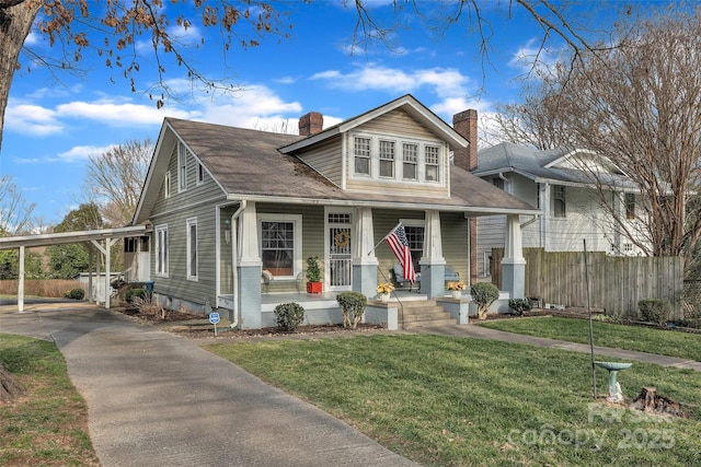 bungalow with a front lawn, a carport, and a porch