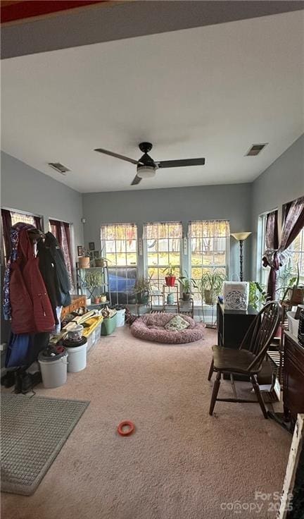 carpeted living room with ceiling fan