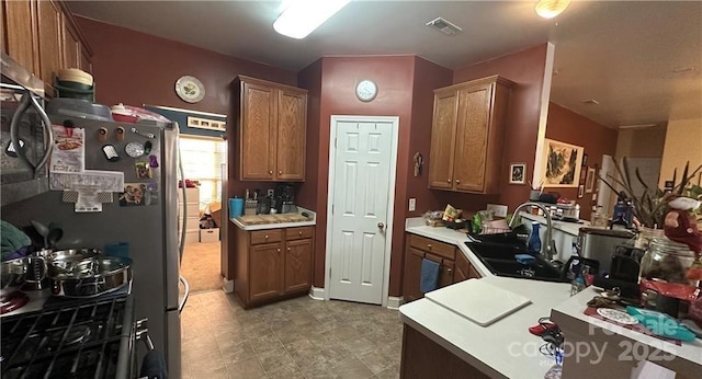 kitchen featuring sink, stainless steel refrigerator, and kitchen peninsula