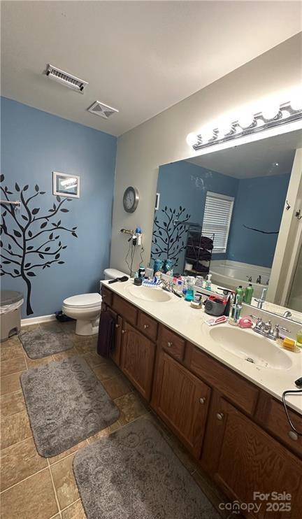 bathroom with vanity, toilet, and a tub