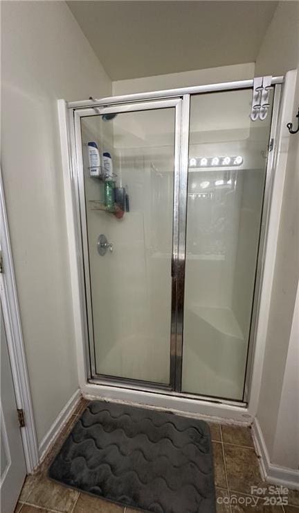 bathroom with tile patterned floors and a shower with door