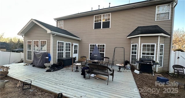 back of house featuring a wooden deck and a fire pit