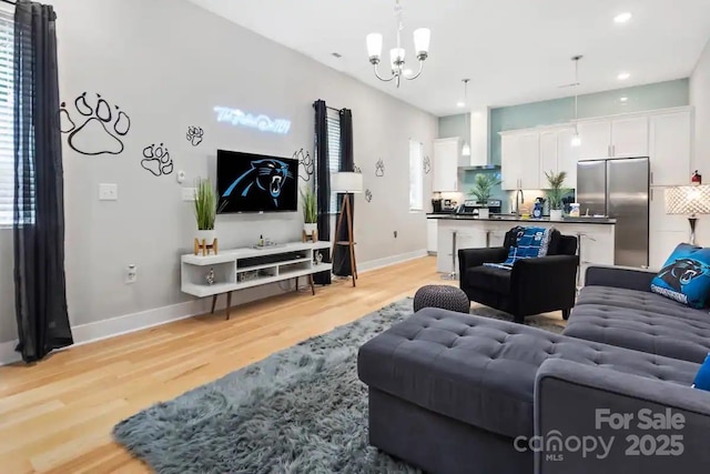 living room featuring sink, light hardwood / wood-style flooring, and a chandelier