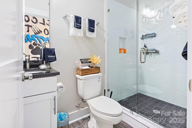 bathroom with an enclosed shower, vanity, hardwood / wood-style flooring, and toilet