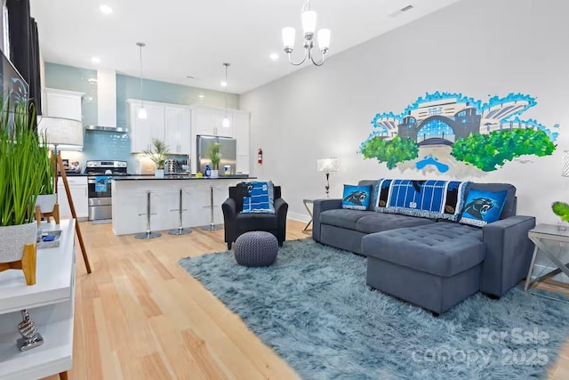 living room with a notable chandelier and light wood-type flooring