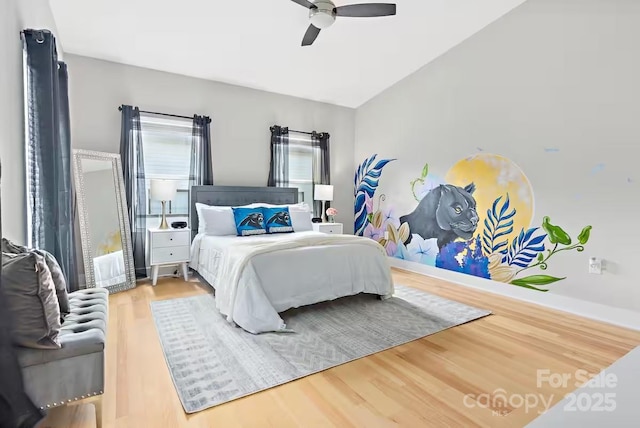 bedroom featuring hardwood / wood-style flooring, ceiling fan, and lofted ceiling