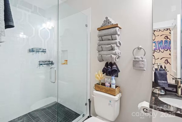 bathroom featuring toilet, vanity, and a shower with shower door