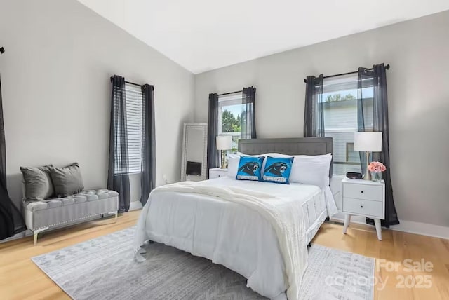 bedroom with wood-type flooring and vaulted ceiling