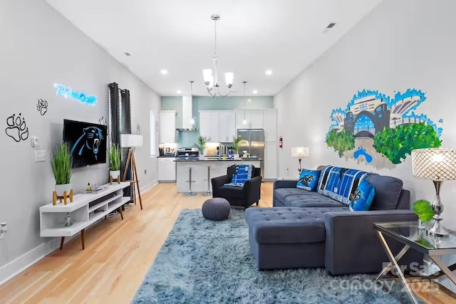 living room featuring an inviting chandelier and light hardwood / wood-style floors