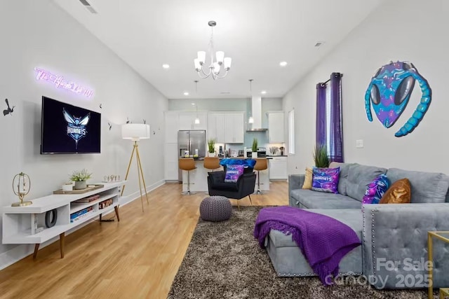 living room with light hardwood / wood-style flooring and a notable chandelier