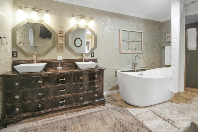 bathroom with crown molding, vanity, a bathing tub, and wood-type flooring