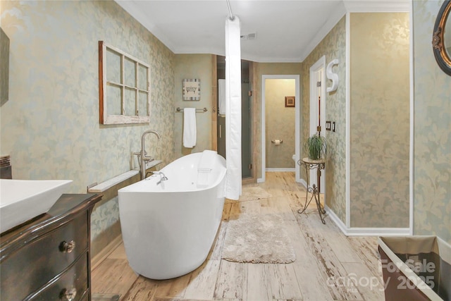 bathroom with vanity, a bathtub, and crown molding