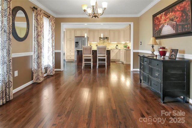 dining room featuring crown molding, dark hardwood / wood-style flooring, and an inviting chandelier