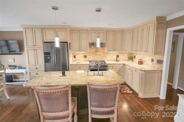 kitchen with pendant lighting, cream cabinets, and appliances with stainless steel finishes