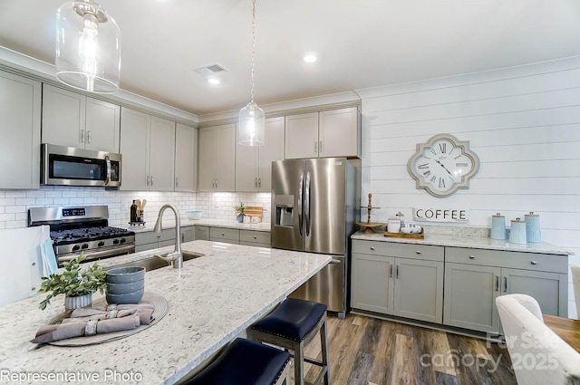 kitchen featuring hanging light fixtures, appliances with stainless steel finishes, and gray cabinets