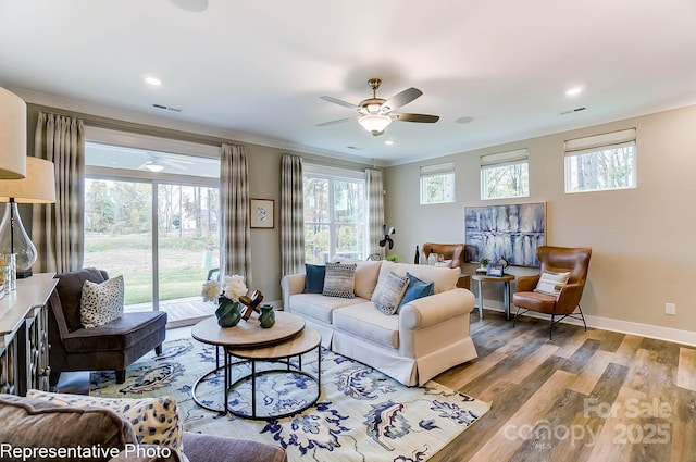 living room with hardwood / wood-style flooring, crown molding, and ceiling fan