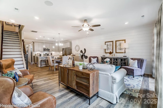 living room with ceiling fan and light hardwood / wood-style flooring