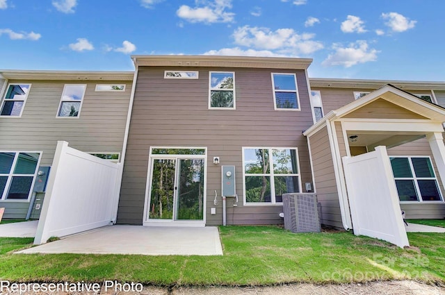 rear view of property with a yard, a patio area, and central air condition unit