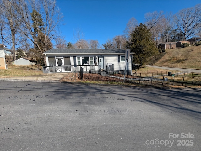 single story home featuring covered porch and a fenced front yard