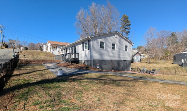 view of side of property featuring fence and a lawn