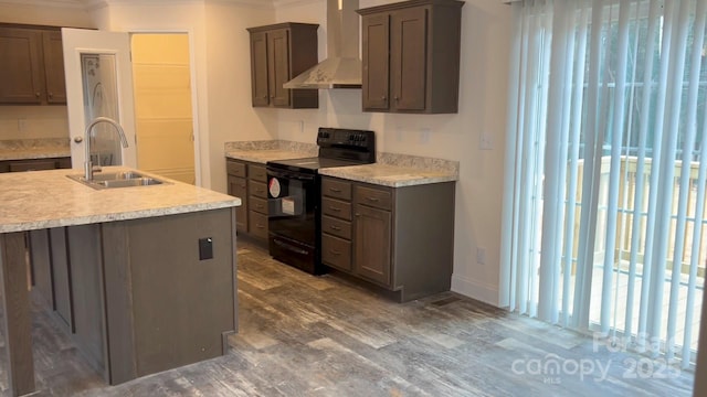 kitchen with wall chimney exhaust hood, black range with electric cooktop, a sink, and light countertops