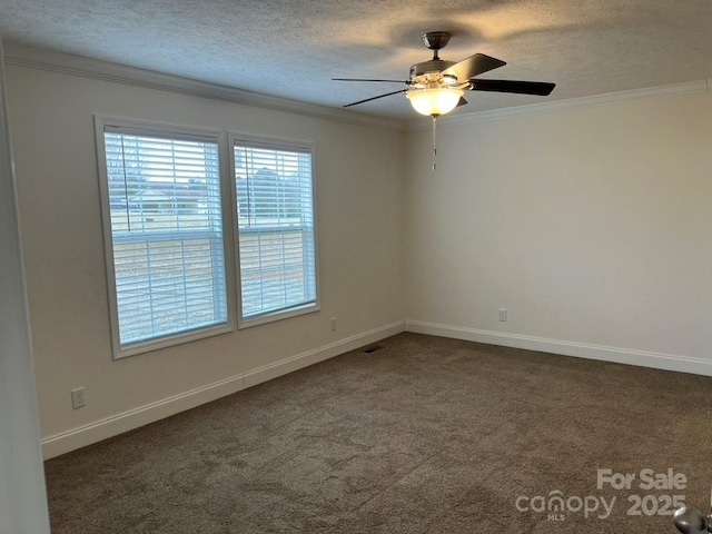 empty room featuring ornamental molding, dark colored carpet, a textured ceiling, and baseboards