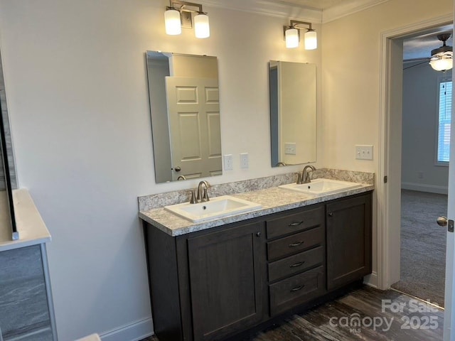 full bathroom featuring double vanity, a sink, a ceiling fan, and baseboards