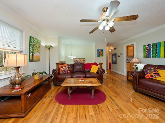 living area with ornamental molding, ceiling fan with notable chandelier, and light wood finished floors