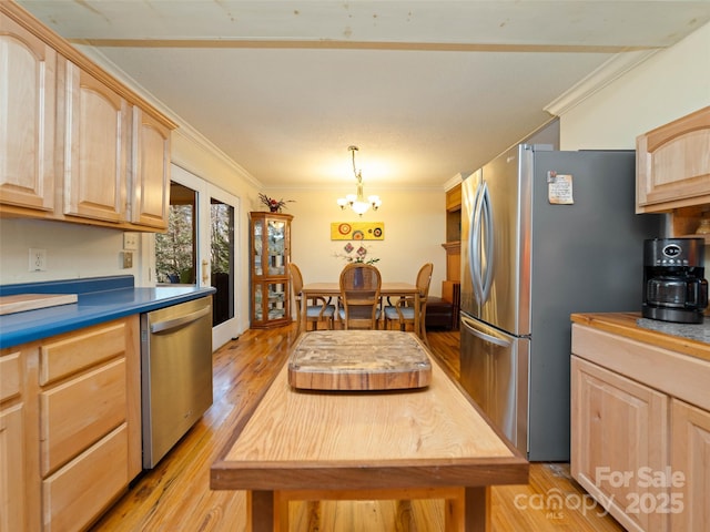 kitchen with a chandelier, light wood finished floors, light brown cabinetry, stainless steel appliances, and ornamental molding