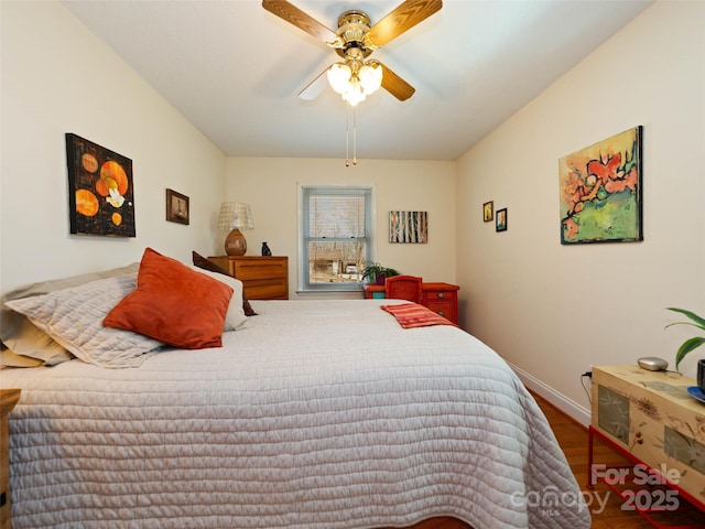 bedroom featuring wood finished floors, baseboards, and ceiling fan