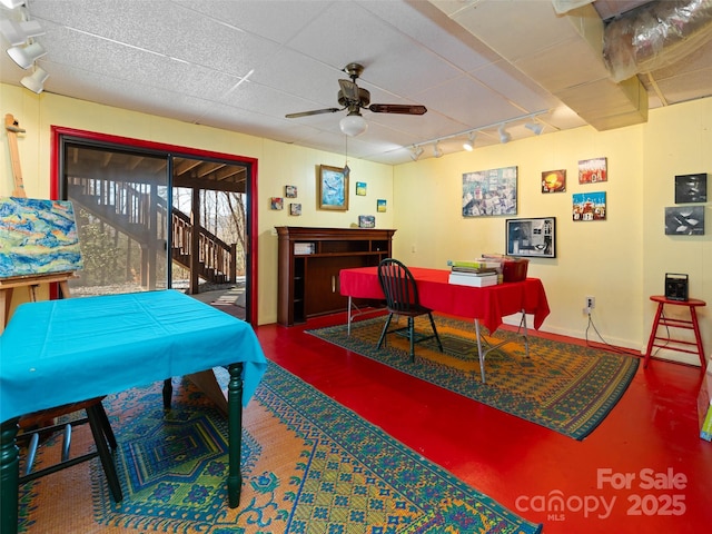 interior space with baseboards, rail lighting, finished concrete floors, and a ceiling fan
