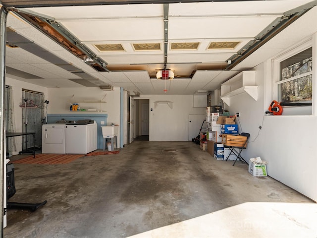 garage featuring independent washer and dryer, a garage door opener, and a sink