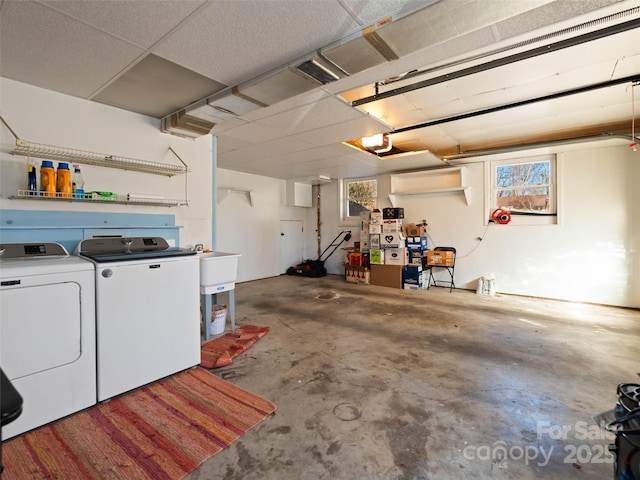 garage with washing machine and clothes dryer and a garage door opener