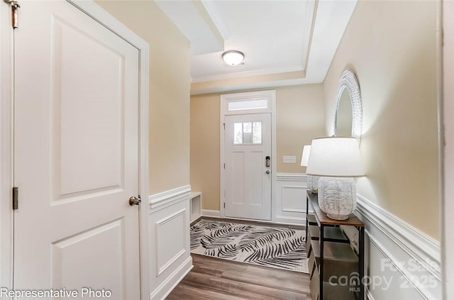 entrance foyer with a tray ceiling, crown molding, and dark hardwood / wood-style floors