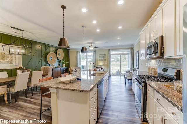 kitchen with sink, white cabinetry, hanging light fixtures, a center island with sink, and stainless steel appliances