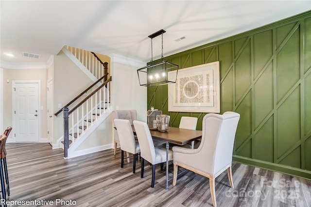 dining space with crown molding and hardwood / wood-style flooring