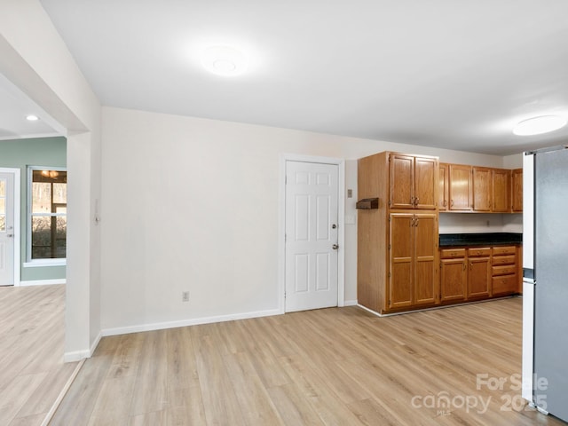 kitchen with stainless steel fridge and light hardwood / wood-style flooring