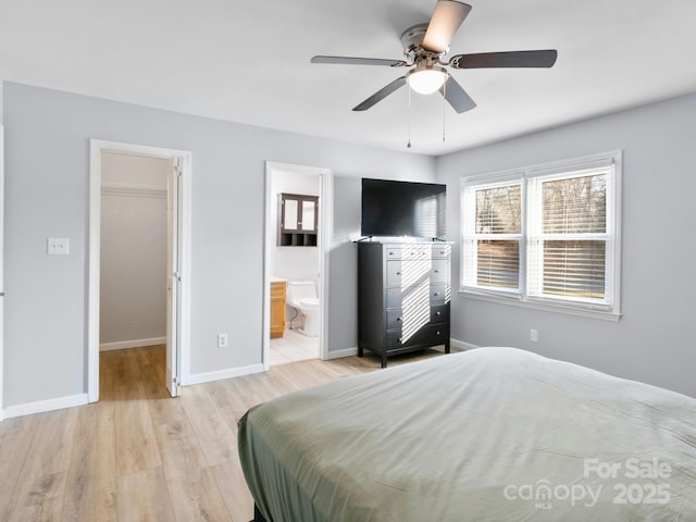 bedroom featuring ceiling fan, connected bathroom, light hardwood / wood-style floors, a walk in closet, and a closet