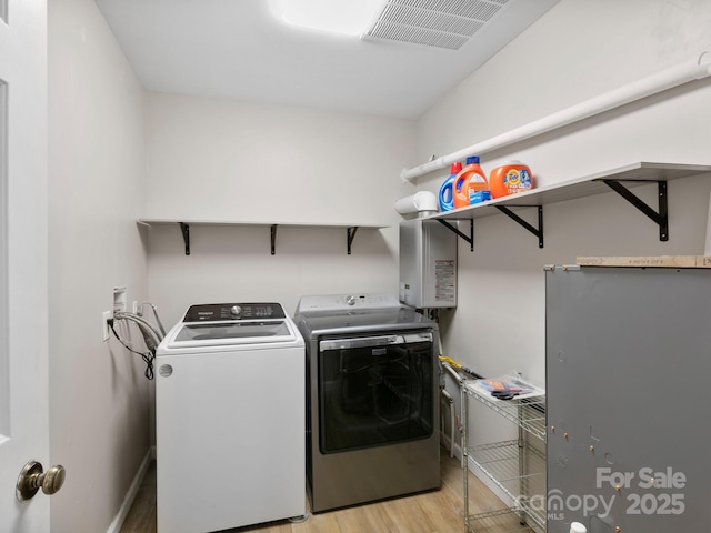 washroom with washer and clothes dryer and light wood-type flooring