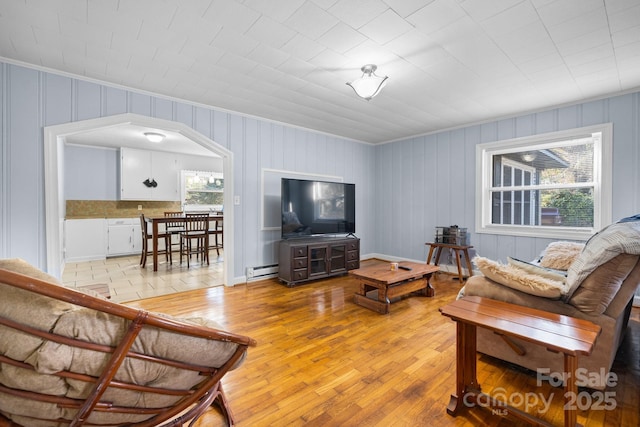 living room with a baseboard radiator and light wood-type flooring