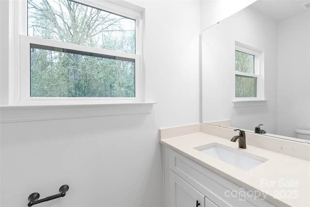 bathroom featuring vanity, toilet, and plenty of natural light