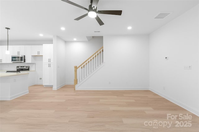 unfurnished living room with ceiling fan and light hardwood / wood-style flooring