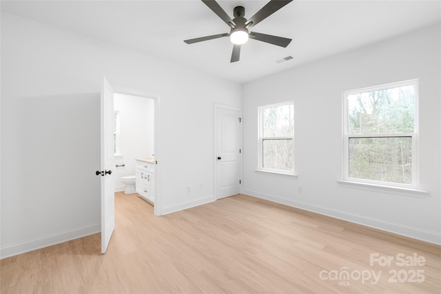 unfurnished bedroom featuring connected bathroom, ceiling fan, and light hardwood / wood-style flooring