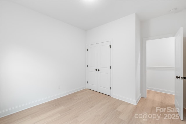 unfurnished bedroom with a closet and light hardwood / wood-style flooring