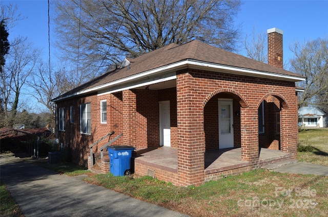 view of side of home with a porch and central AC