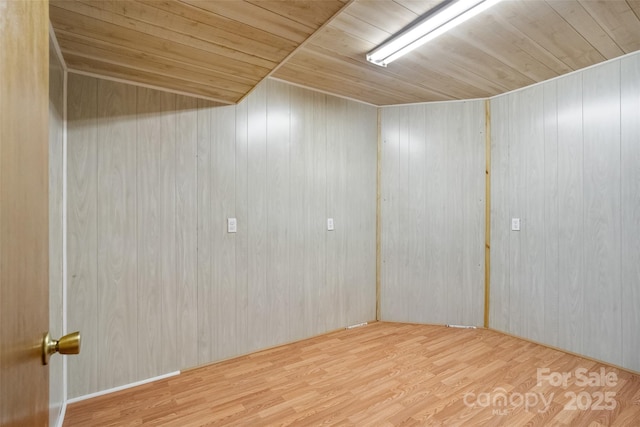 spare room featuring wood ceiling and hardwood / wood-style flooring