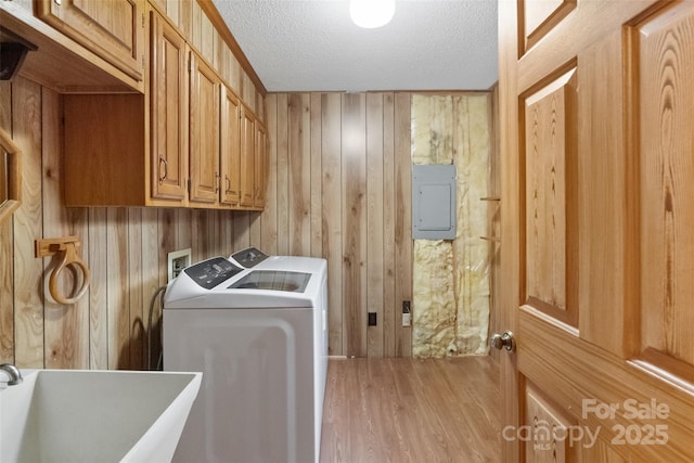 laundry area with sink, electric panel, cabinets, washer and dryer, and a textured ceiling