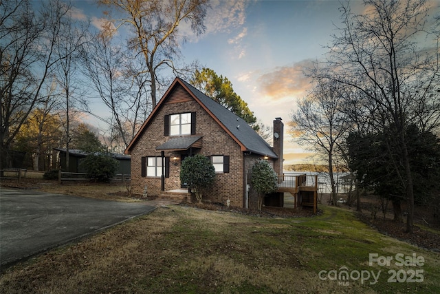 view of front of house featuring a wooden deck and a lawn