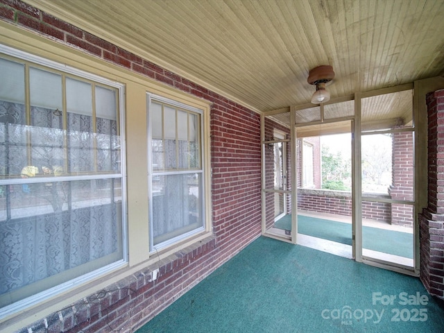 113 2nd St, Spencer, NC 28159 - unfurnished sunroom with brick wall, carpet floors, and wooden ceiling