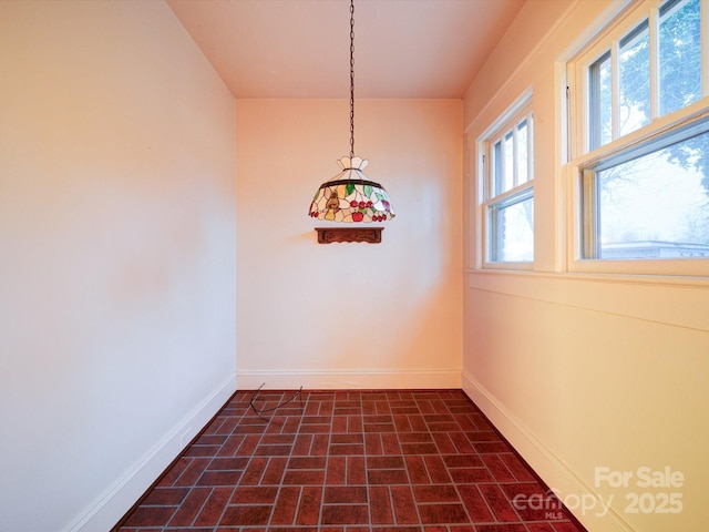 113 2nd St, Spencer, NC 28159 - unfurnished dining area with brick patterned floors and baseboards